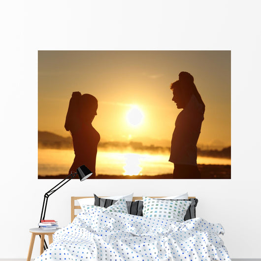Silhouette of a fitness couple stretching at sunrise Wall Decal