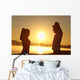 Silhouette of a fitness couple stretching at sunrise Wall Decal