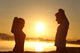Silhouette of a fitness couple stretching at sunrise Wall Decal