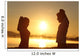 Silhouette of a fitness couple stretching at sunrise Wall Decal
