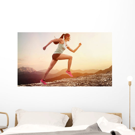 Junge joggerin läuft auf berg Wall Mural