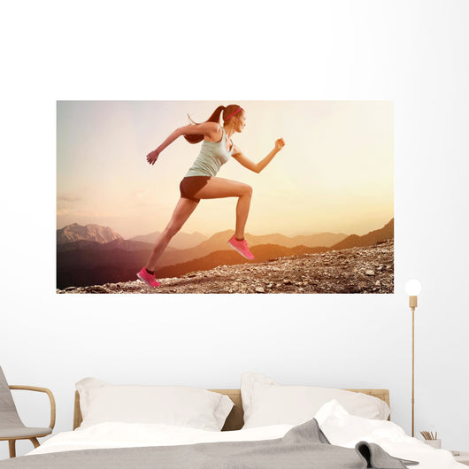 Junge joggerin läuft auf berg Wall Mural