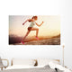 Junge joggerin läuft auf berg Wall Mural