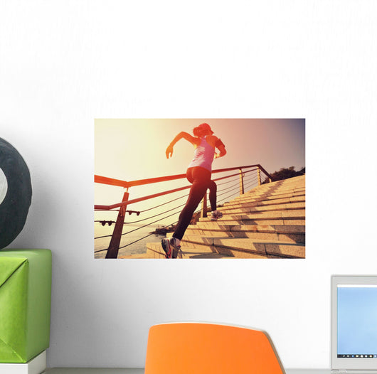 young fitness woman running on seaside stone stairs Wall Mural