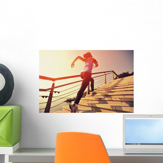 young fitness woman running on seaside stone stairs Wall Mural
