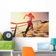 young fitness woman running on seaside stone stairs Wall Mural