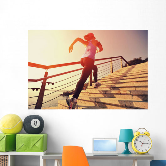 young fitness woman running on seaside stone stairs Wall Mural