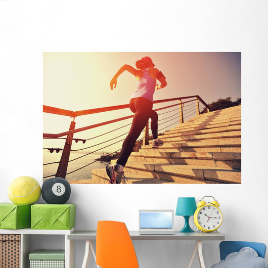 young fitness woman running on seaside stone stairs Wall Mural