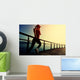 young fitness woman running on sunrise seaside boardwalk Wall Mural