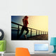 young fitness woman running on sunrise seaside boardwalk Wall Mural