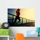 young fitness woman running on sunrise seaside boardwalk Wall Mural
