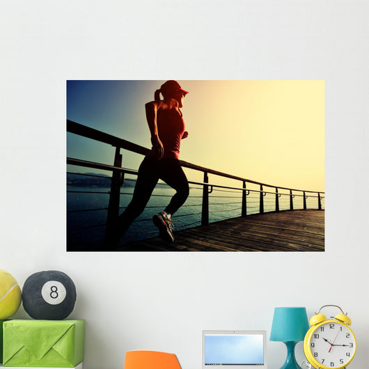 young fitness woman running on sunrise seaside boardwalk Wall Mural