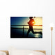 young fitness woman running on sunrise seaside boardwalk Wall Mural