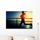 young fitness woman running on sunrise seaside boardwalk Wall Mural