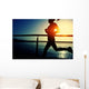 young fitness woman running on sunrise seaside boardwalk Wall Mural