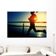 young fitness woman running on sunrise seaside boardwalk Wall Mural