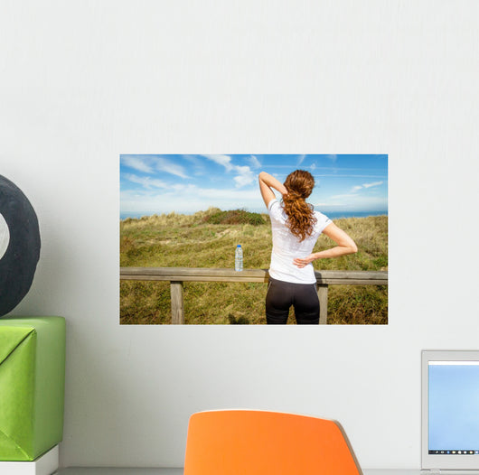 Athletic woman touching neck and back muscles by injury Wall Mural