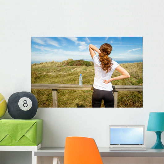 Athletic woman touching neck and back muscles by injury Wall Mural
