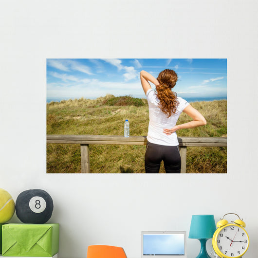 Athletic woman touching neck and back muscles by injury Wall Mural