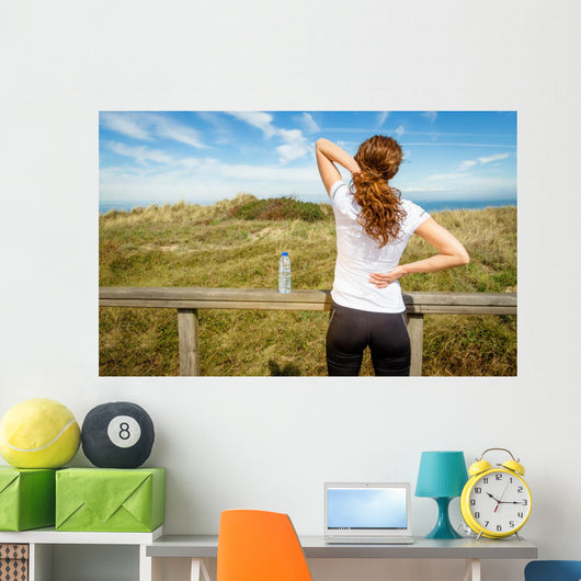 Athletic woman touching neck and back muscles by injury Wall Mural