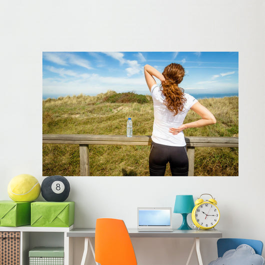 Athletic woman touching neck and back muscles by injury Wall Mural