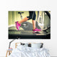 Fitness girl running on treadmill. With muscular legs in gym. Wall Mural