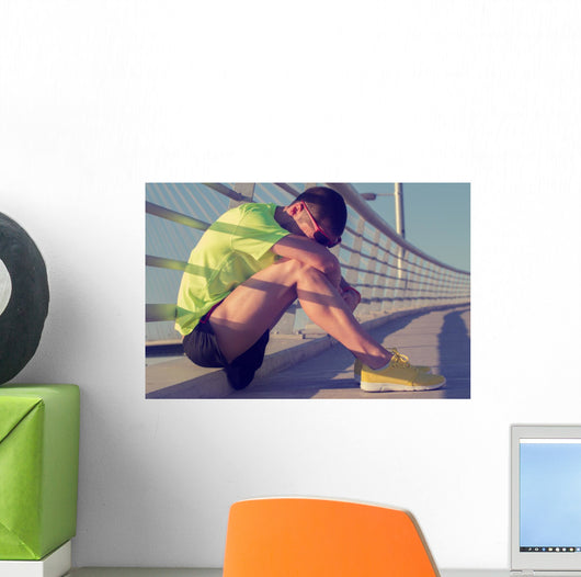 Tired/injured jogger on a big bridge. Wall Mural