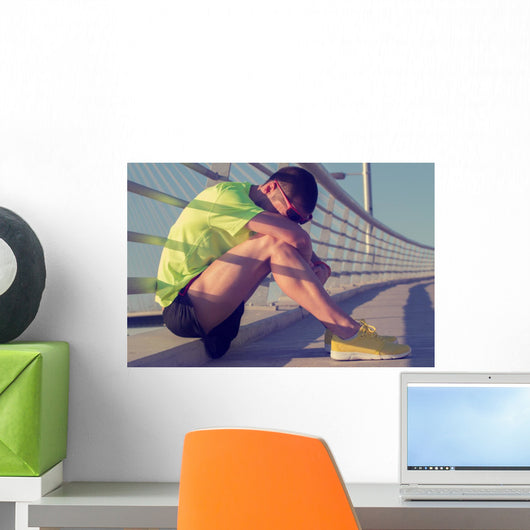 Tired/injured jogger on a big bridge. Wall Mural