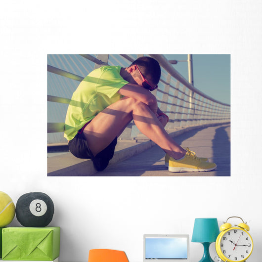Tired/injured jogger on a big bridge. Wall Mural