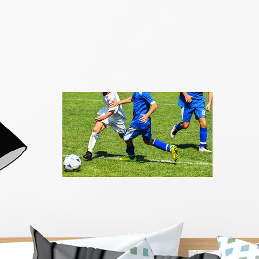 Young soccer players in action Wall Mural