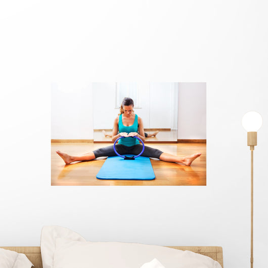 Fitness teacher making exercisese with the circle tool Wall Mural