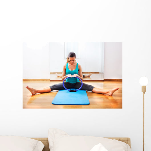 Fitness teacher making exercisese with the circle tool Wall Mural
