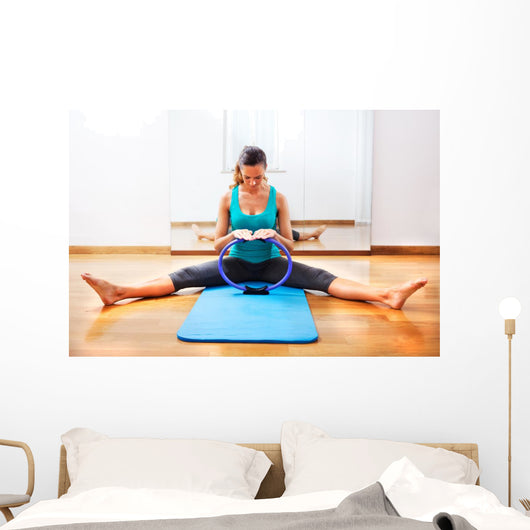 Fitness teacher making exercisese with the circle tool Wall Mural