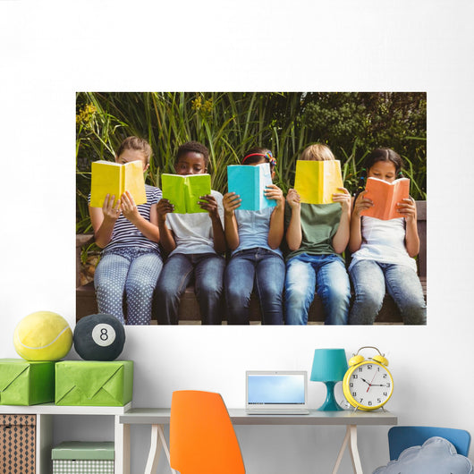 Children reading books at park Wall Mural