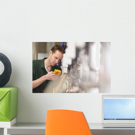 Male technician repairing agriculture machinery Wall Mural