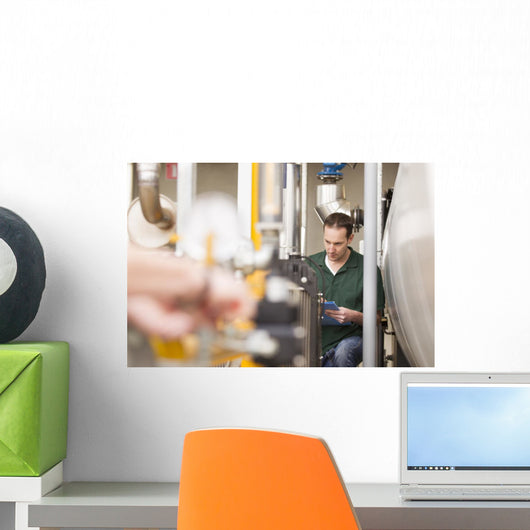 Male technician repairing agriculture machinery Wall Mural
