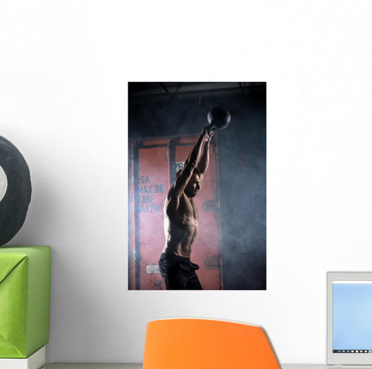 Beautiful athlete doing kettlebell swings. Profile picture. Athl Wall Mural