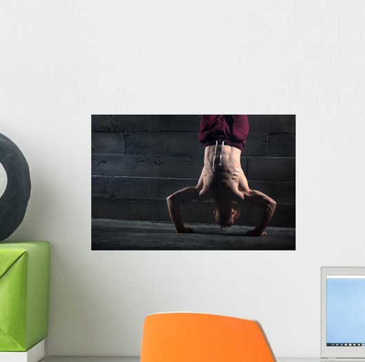 Athlete with naked torso doing push-ups on his hands while stand Wall Mural