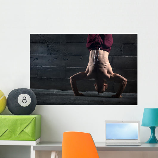 Athlete with naked torso doing push-ups on his hands while stand Wall Mural