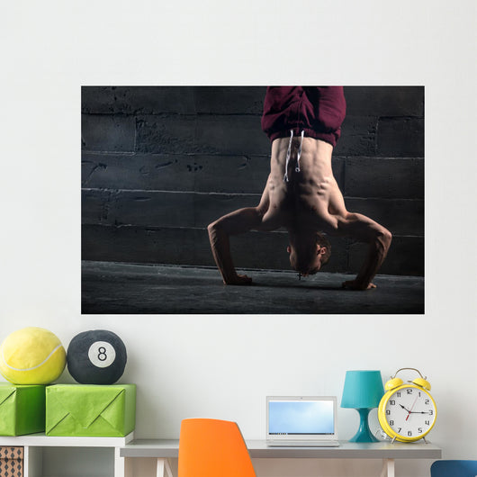 Athlete with naked torso doing push-ups on his hands while stand Wall Mural