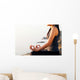 The woman meditating in a yoga pose on the tropical beach. Wall Mural