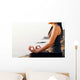 The woman meditating in a yoga pose on the tropical beach. Wall Mural
