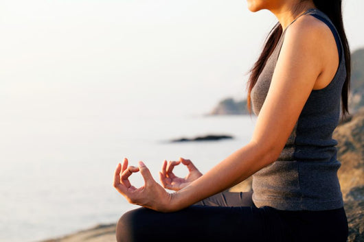 The woman meditating in a yoga pose on the tropical beach. Wall Mural