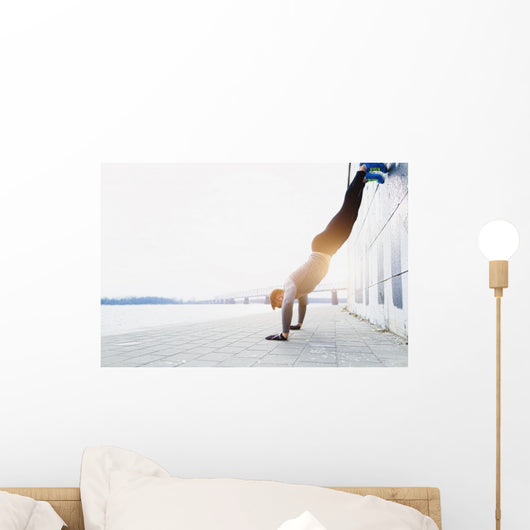 Young athlete is doing vertical push ups Wall Mural