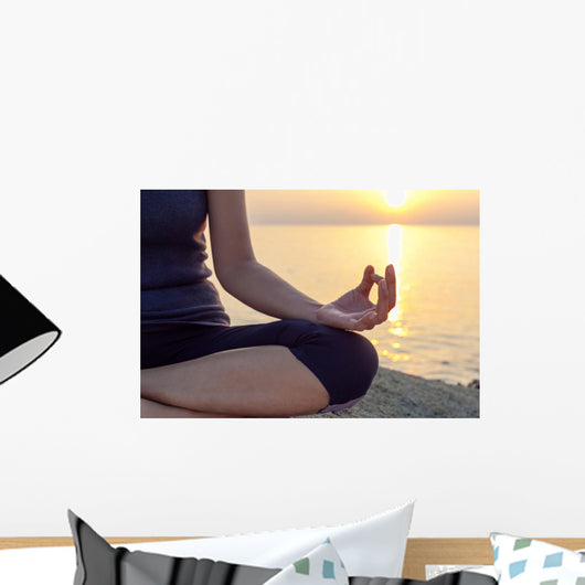 The woman meditating in a yoga pose on the tropical beach. Wall Mural