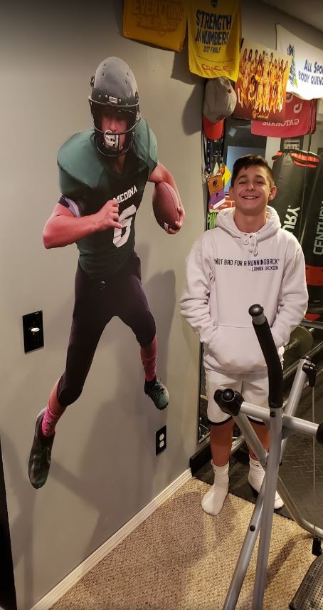 Life size sports wall decal with a football on a bedroom wall