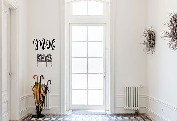 A Wall Decal of the Initials "MH" Above a Key Holder by the Doorway