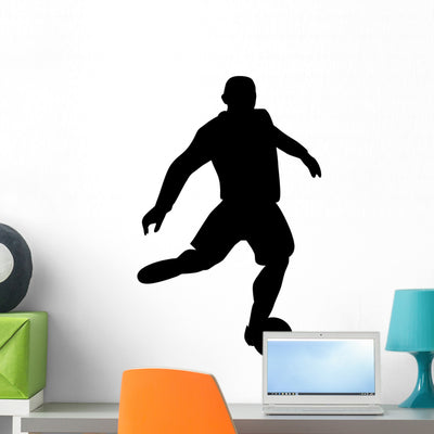 Kicking Soccer Silhouette Wall Decal shown on a wall