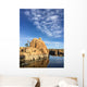 Rock island in a lake with blue sky and clouds Wall Mural