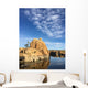 Rock island in a lake with blue sky and clouds Wall Mural